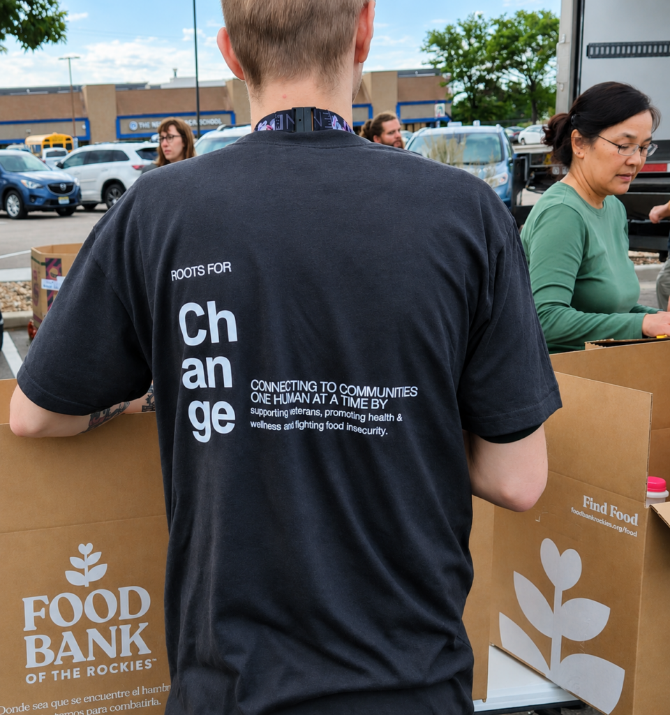 A volunteer in a Roots for Change shirt packing boxes at Food Bank of the Rockies